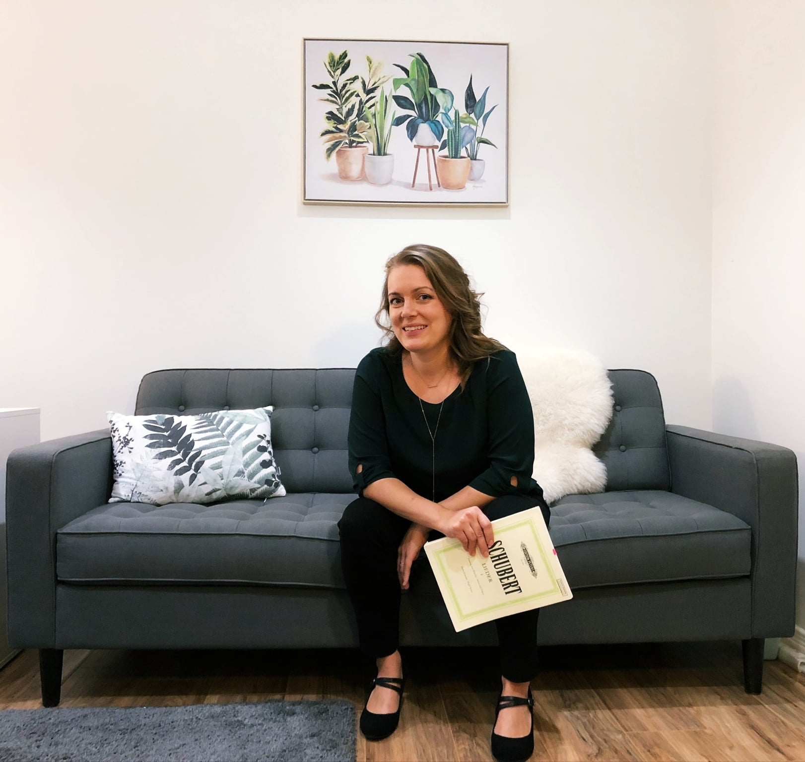 London Ontario Voice Teacher Suzanne Schaafsma of NewSong Academy sitting on a couch in her teaching studio
